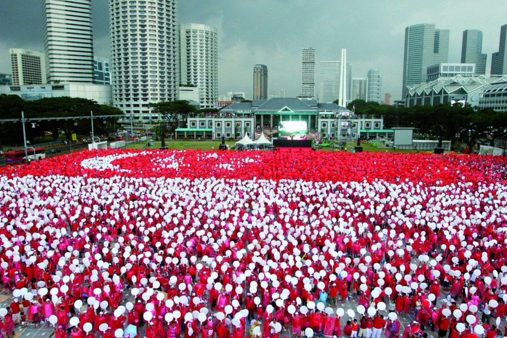 Rows of people wearing red and white on Singapore National Day Parade